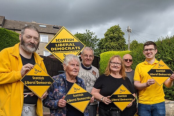 Photo of Renfrewshire Liberal Democrat campaigners holding up orange diamonds with Scottish Liberal Democrats written on them