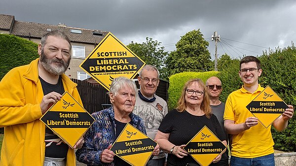 Photo of Renfrewshire Liberal Democrat campaigners holding up orange diamonds with Scottish Liberal Democrats written on them