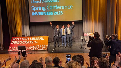 Alex Cole-Hamilton, Jamie Greene and Ed Davey taking in the applause of Lib Dem members at conference.