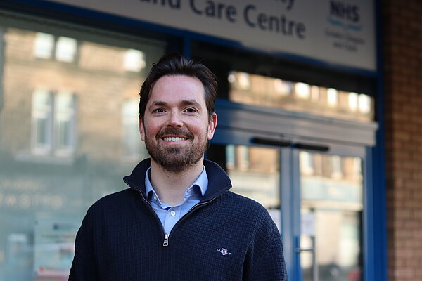 Adam Harley smiling outside a health centre
