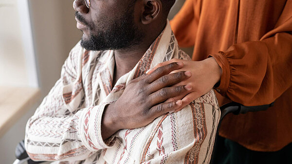 Person touching another's shoulder in sign of affection